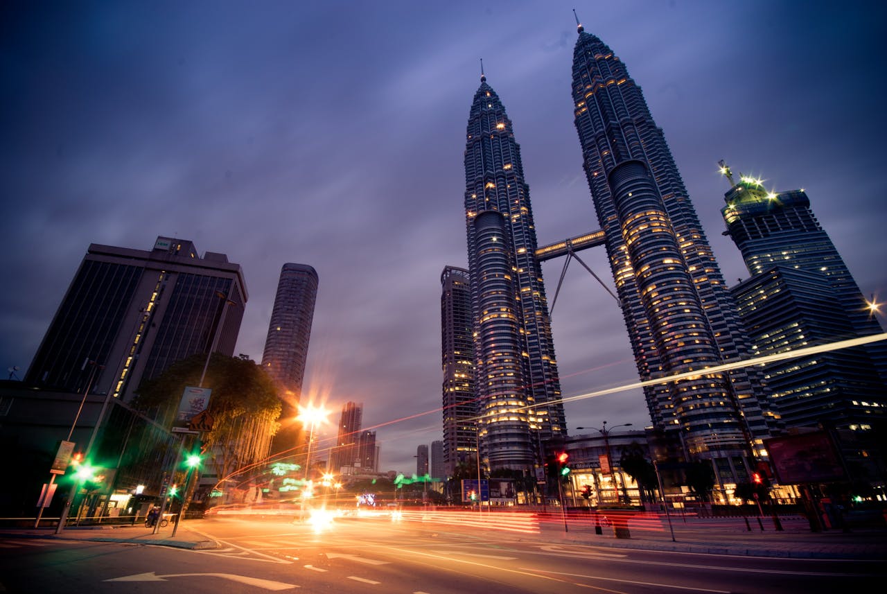who-we-are Beautiful long exposure of Kuala Lumpur at night showcasing iconic Petronas Towers and urban lights.
